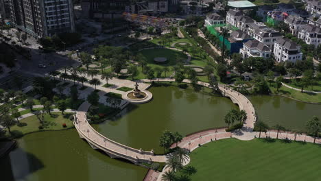 aerial-view-of-a-beautifully-landscaped-park-on-a-clear-sunny-day-with-colorful-children's-playground-tennis-courts-and-putting-green