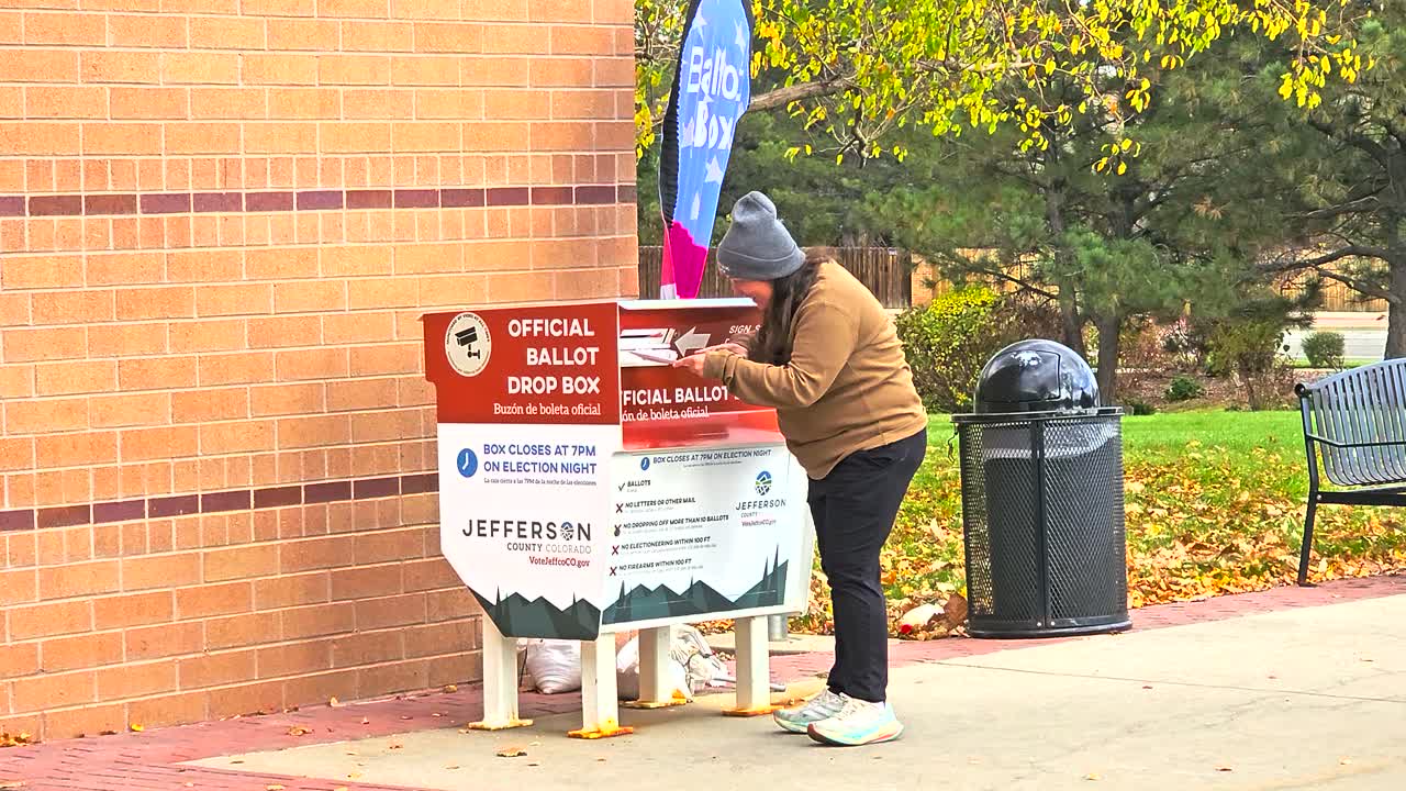 Voting securely is shown as a woman drops her mail-in ballot envelope into an official ballot box, representing civic duty, freedom, trust, equality, inclusivity, safety, the importance of democracy