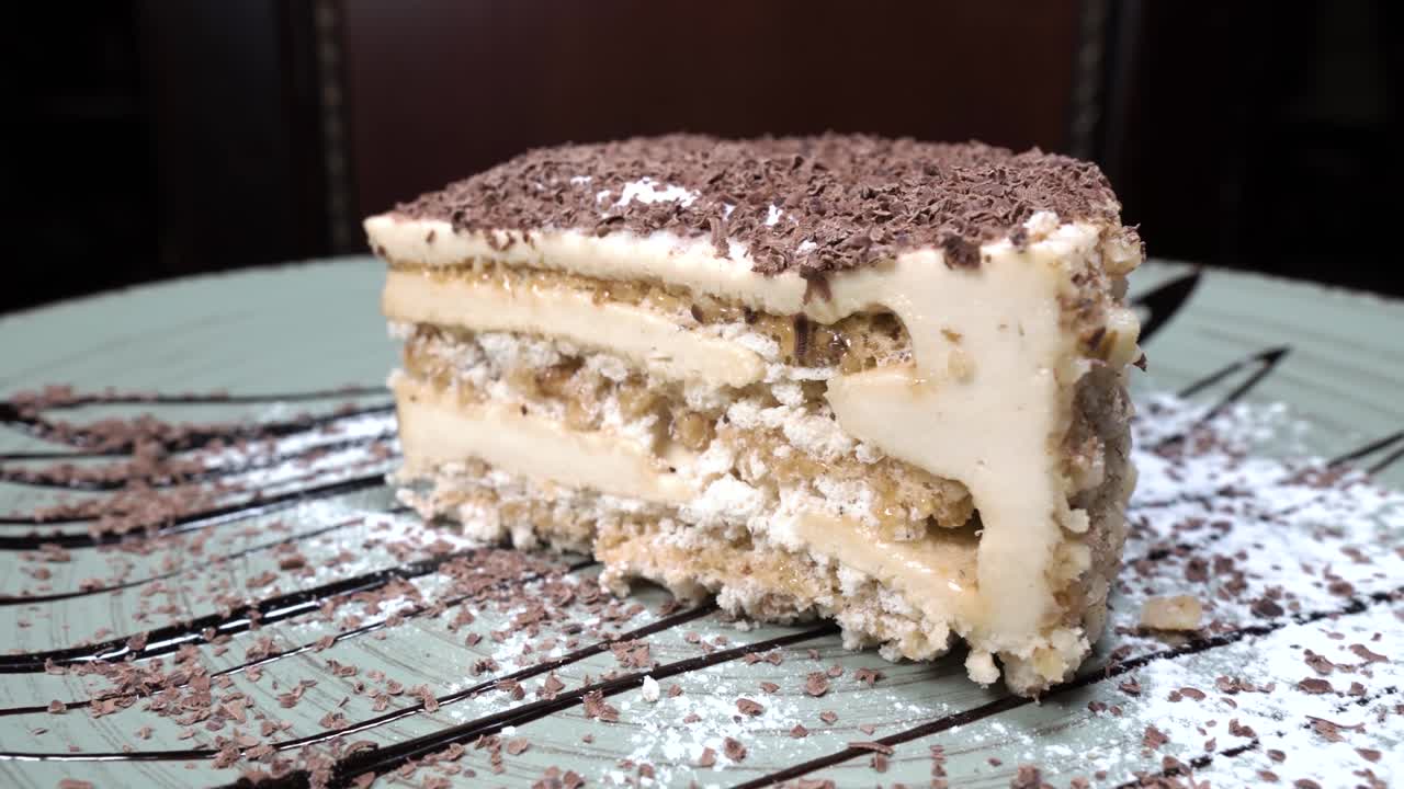 Güzel bir tabakta dönen bir dilim pasta. Restoran tatlısı. Dönen yiyecek. Kafede yemeğin sunumu.