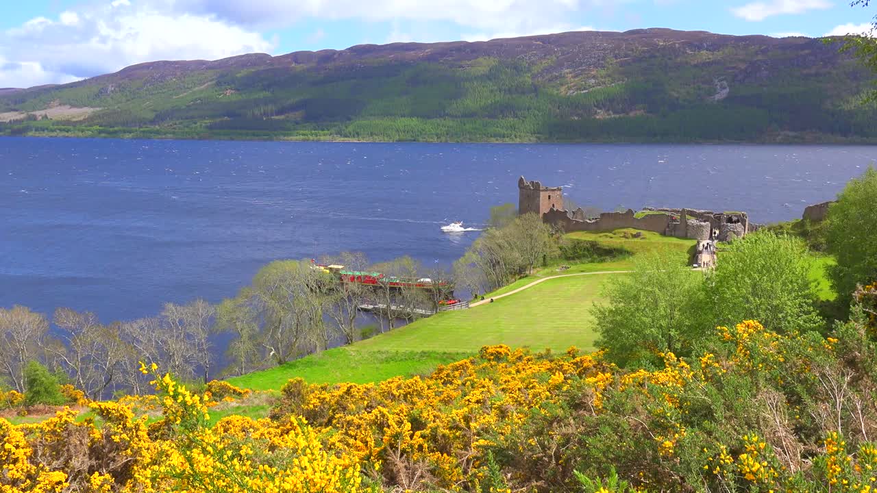 쾌속정이 지나가는 네스호 성 스코틀랜드의 설정 샷