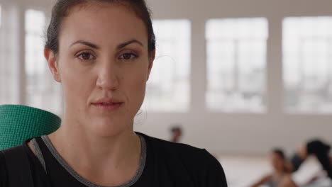 retrato hermosa mujer de yoga sonriendo con confianza mujer caucásica disfrutando de un estilo de vida saludable con gente practicando en el fondo del gimnasio