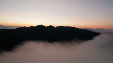 epic silhouette scenery of mountain in madeira flying backwards into clouds