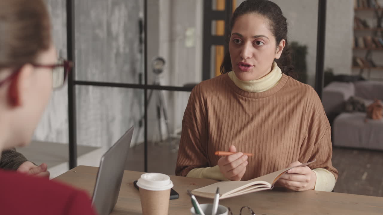 Mixed-Race Woman Interviewing Unrecognizable Candidate