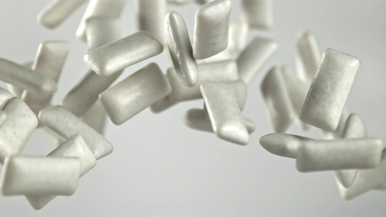 Trozos de chicle blanco cayendo en cámara lenta