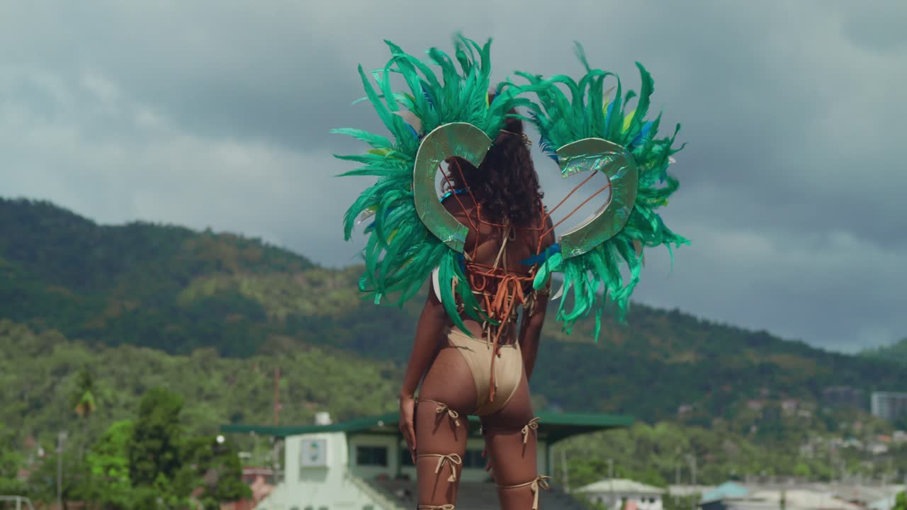 una joven vestida de carnaval se mueve con gracia en medio de la belleza tropical de las costas caribeñas de trinidad.