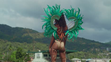 una joven vestida de carnaval se mueve con gracia en medio de la belleza tropical de las costas caribeñas de trinidad.