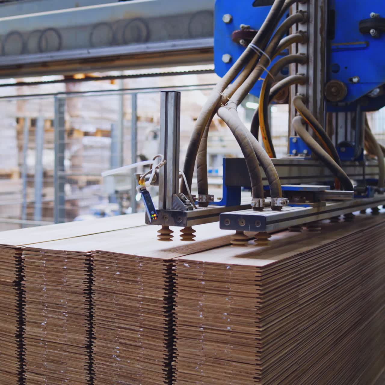Robotic equipment in the wood factory. Interior of industrial plant for production of wooden furniture. Pile of parquet boards.