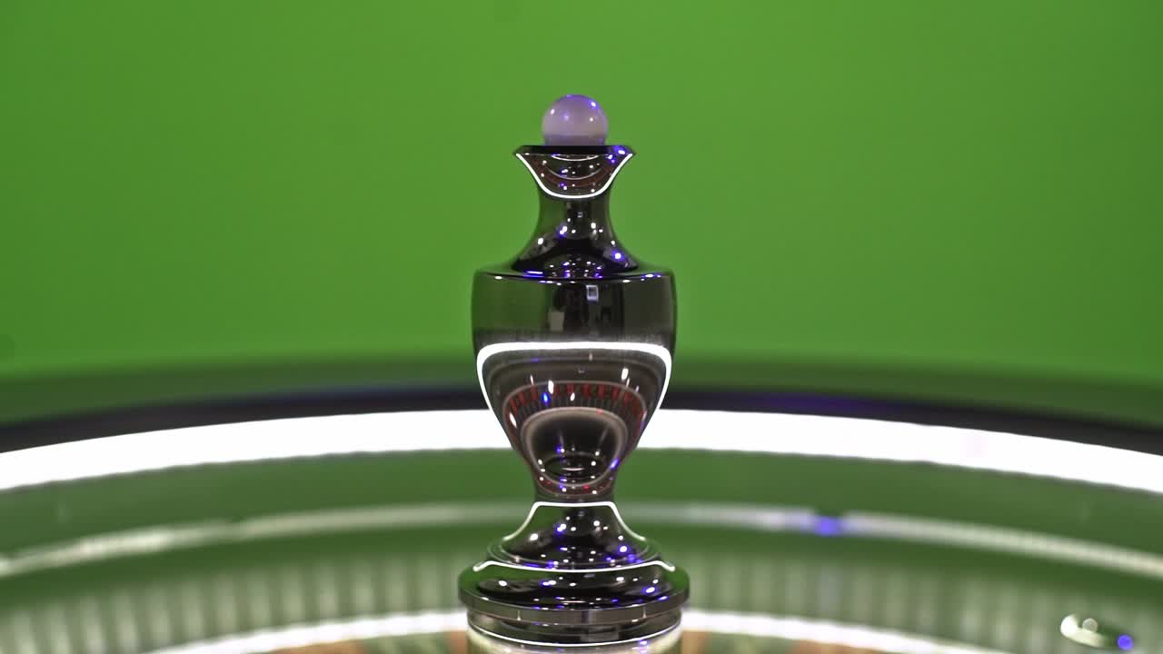 Roulette ball spinning on the center of a roulette wheel, isolated on a green screen background