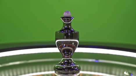 roulette ball spinning on the center of a roulette wheel, isolated on a green screen background