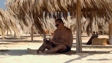 Relajándose-En-La-Playa-Con-Una-Computadora-Portátil