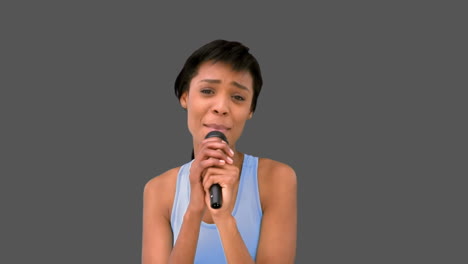 una mujer hermosa cantando en el micrófono.