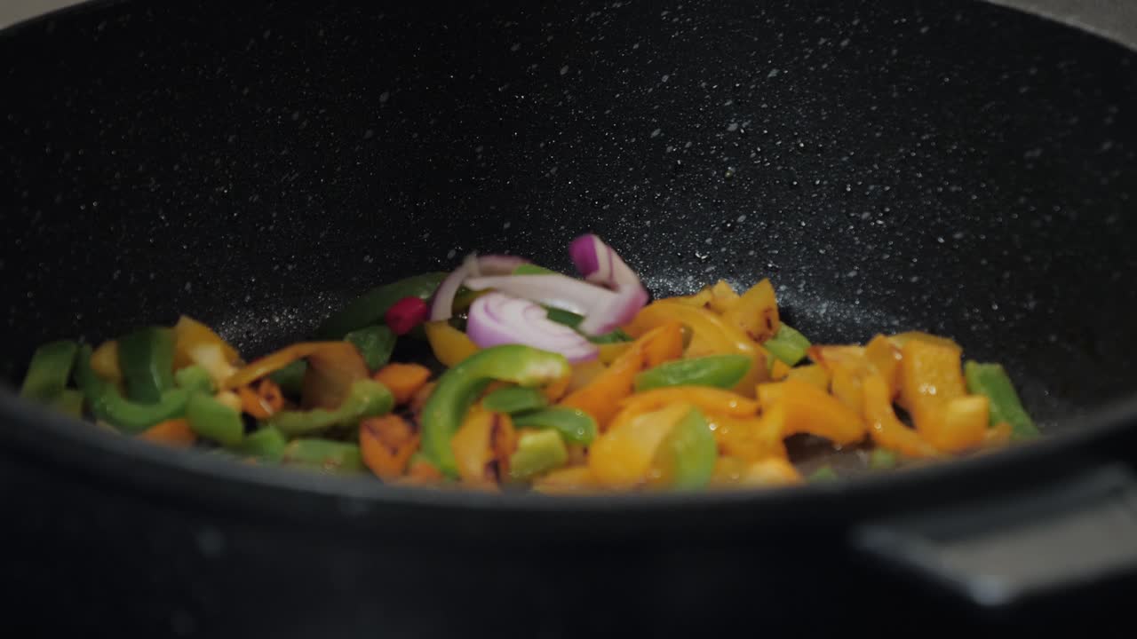 Ripresa al rallentatore con controllo di movimento di paprika in una padella.
