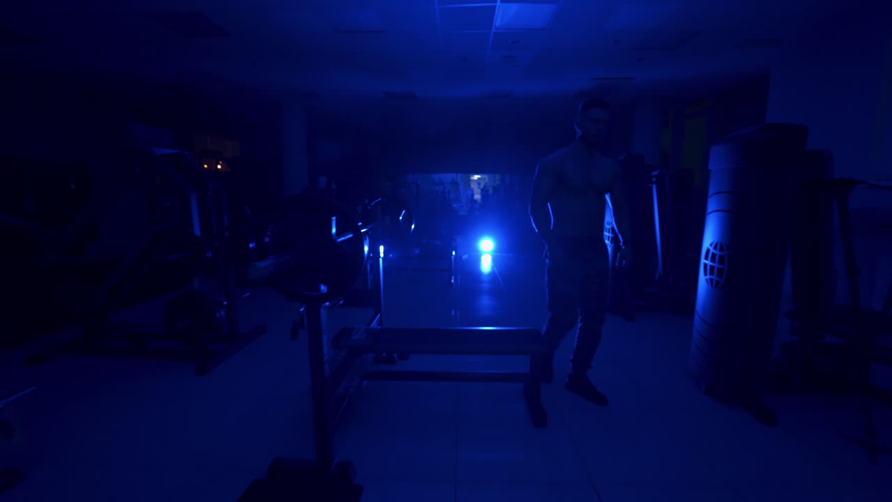 Man preparing for training. Handsome athletic sportsman preparing for training in dark gym