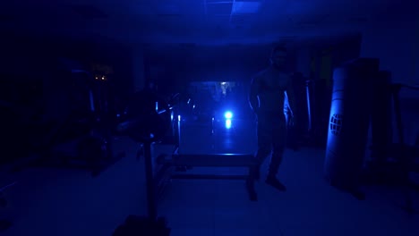 man preparing for training. handsome athletic sportsman preparing for training in dark gym