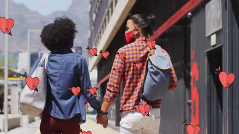 animación de corazones caídos sobre una pareja diversa con máscaras faciales tomados de la mano en la calle