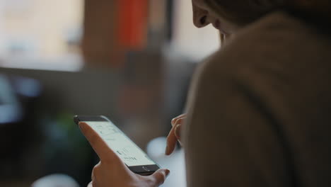 close up of womans hands using smart phone technology to read architectural plans