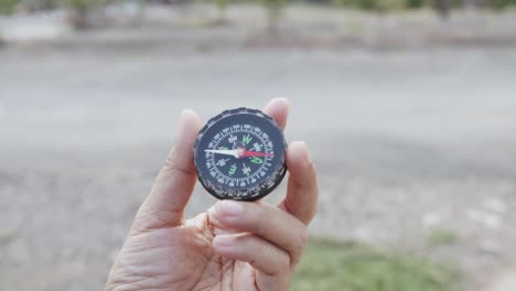 front view, black compass spins around in a transparent hand.