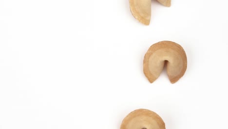 close-up of a number of traditional chinese fortune cookies spinning slowly on white table. international traditional concept. isolated, on white background.