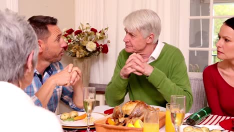 Familia-De-Tres-Generaciones-Cenando-Juntos-De-Navidad