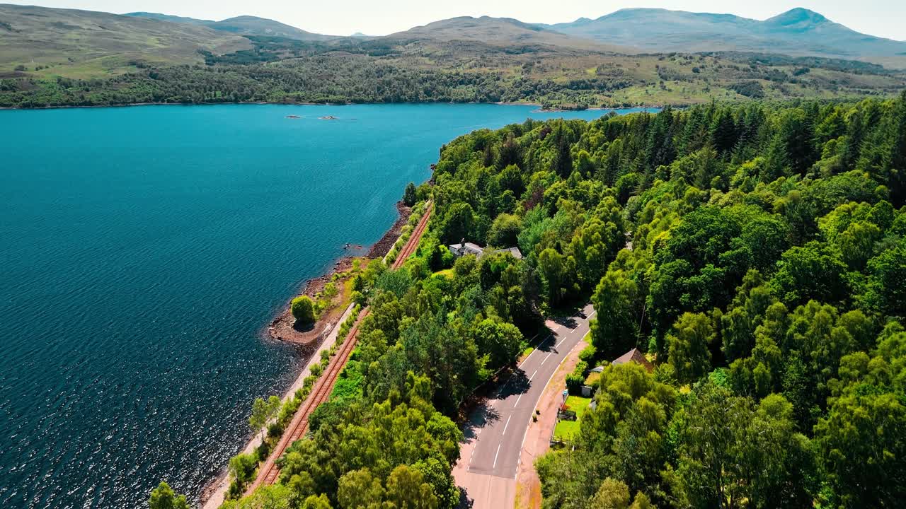 Scenic aerial view of a lake, forest, and road in the mountains