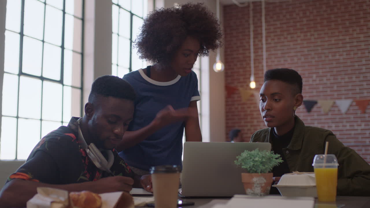 creative black business people meeting team leader woman training colleagues sharing ideas on laptop computer brainstorming in modern office workplace