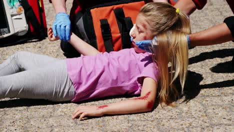 paramedics examining injured girl