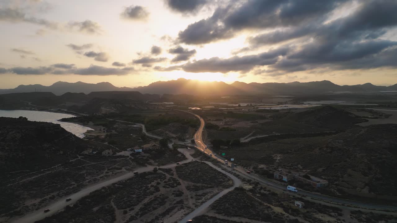 Aerial view going up of a golden sunset shinning between the mountains in the Region of Murcia - Southern Spain - Beautiful Spanish landscape