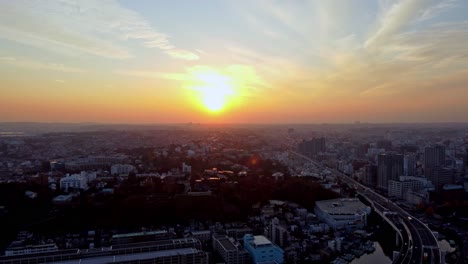 sunset over a bustling cityscape with warm hues and clear skies, aerial view