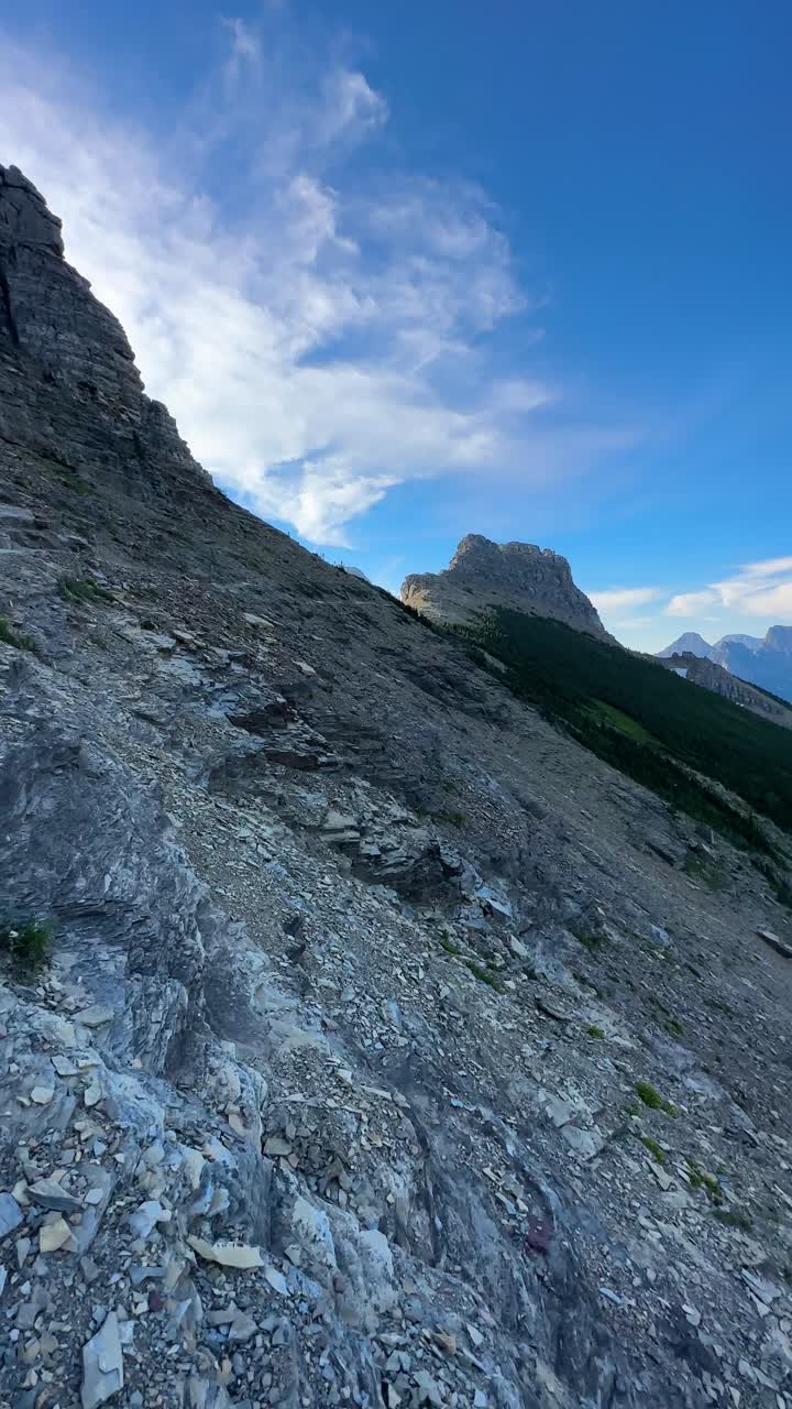 vista vertical, mujer caminando en el sendero highline, parque nacional glacier, montana estados unidos