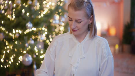 woman takes handmade silver christmas baubles from box