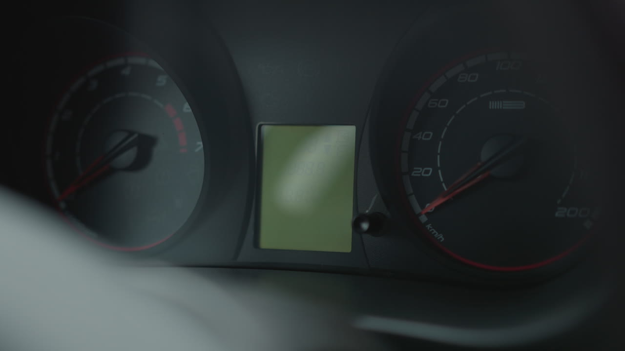 Instrument cluster dashboard illuminates multiple warning lights and digital display readings including time odometer and fuel gauge bars on engine start highlighting interior details