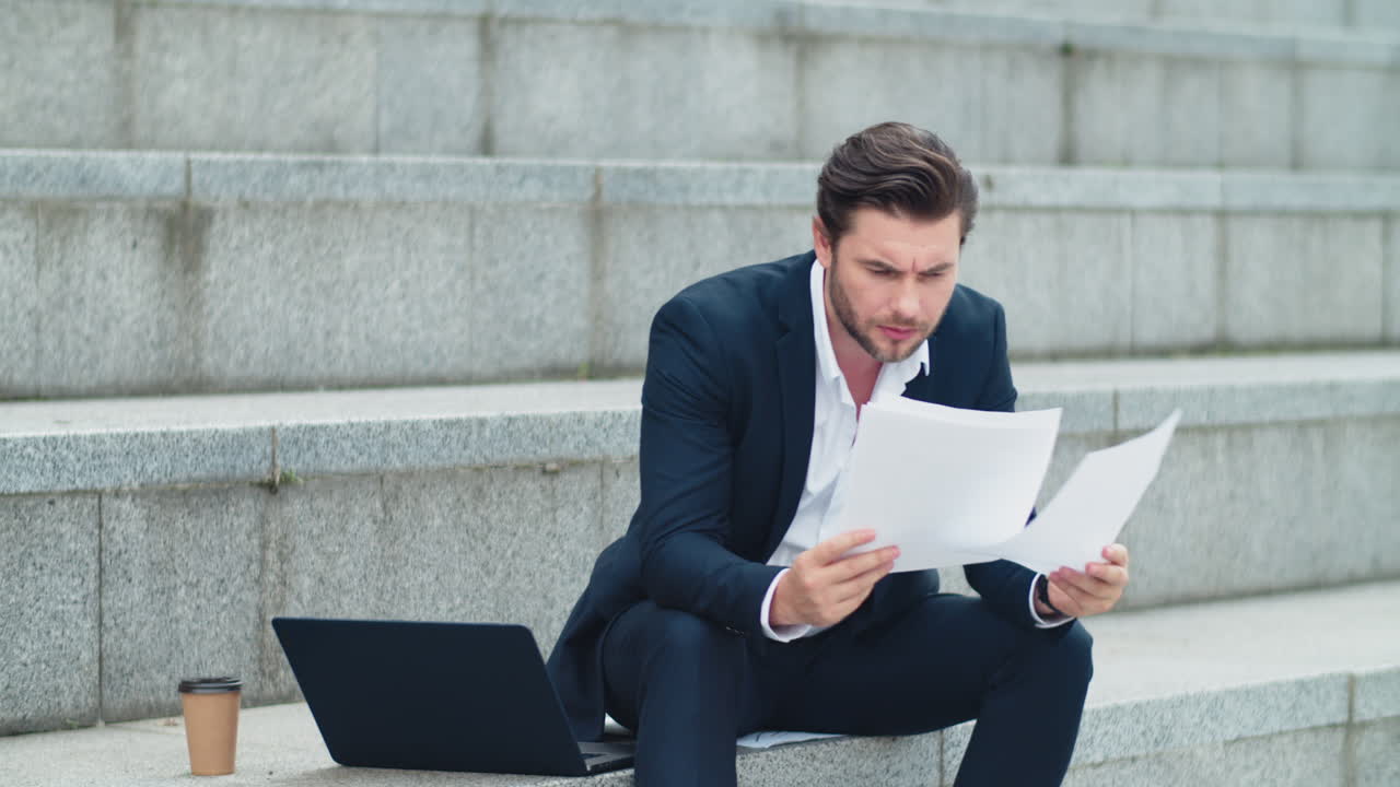 Business man working with documents on street. Entrepreneur reading documents