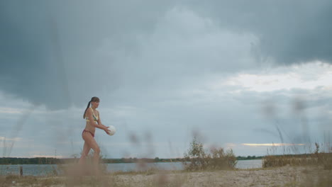 Una-Mujer-Esbelta-En-Bikini-Deportivo-Está-Sirviendo-Pelota-En-Un-Partido-De-Voleibol-De-Playa-En-El-Día-De-Verano