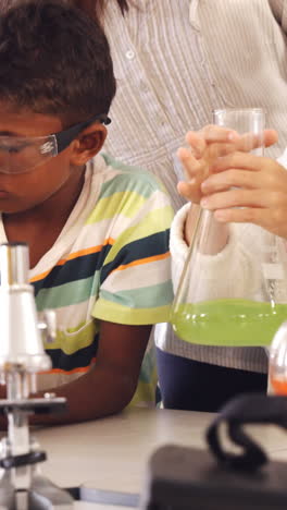 niños de la escuela haciendo un experimento químico en el laboratorio