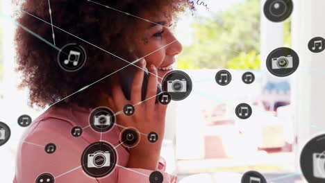 Animation of network of connected icons in circles over african americanwoman using smartphone