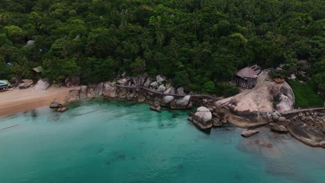 aerial footage of a rocky beach, lush jungle, and turquoise sea in thailand. tropical coastline with scenic rocks, forest, and clear water. perfect for travel, tourism, nature, and adventure projects.