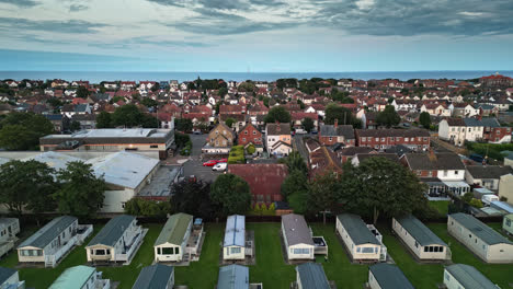 Aerial-drone-footage-showcases-Skegness-town-at-summer-sunset,-revealing-holiday-park,-caravans,-and-beach