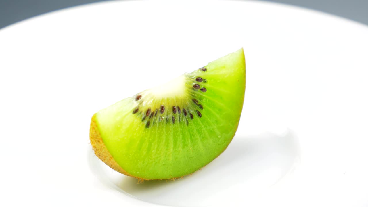 Fresh kiwi slice is slowly rotating in the studio with the details.