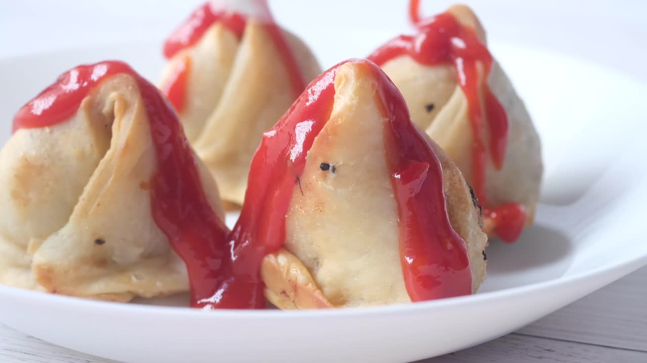 deliciosas samosas fritas con salsa roja