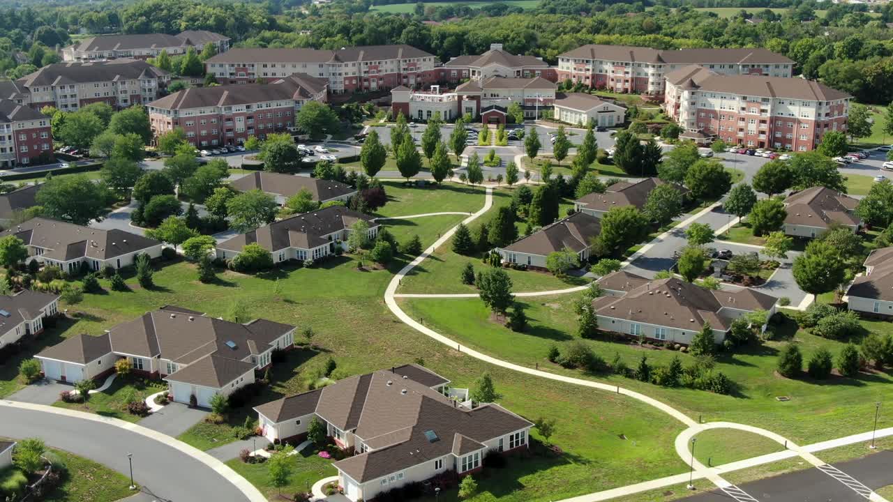 Pullback rising aerial reveals large retirement home community, senior living, USA America 55-plus community for retirees, healthcare, nursing care, assisted living, independent aging at home