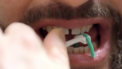 interdental cleaning action close up: man using floss pick device