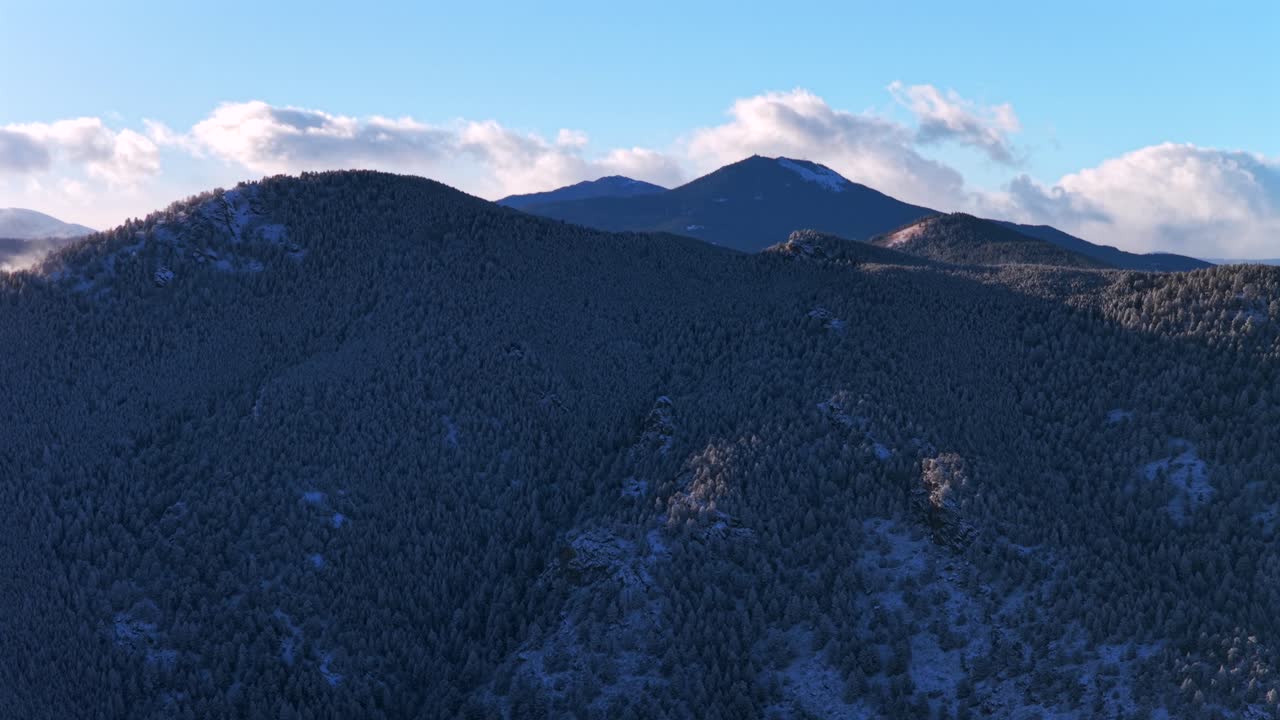 Snow covered wind blown Bergen Peak Elk Meadow Park wildlife sunny sunset Evergreen Colorado aerial drone blue sky foothills valley forest Front Range Rocky Mountains circle left motion