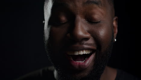 Euphoric-afro-guy-posing-indoors.-African-man-saying-wow-on-black-background