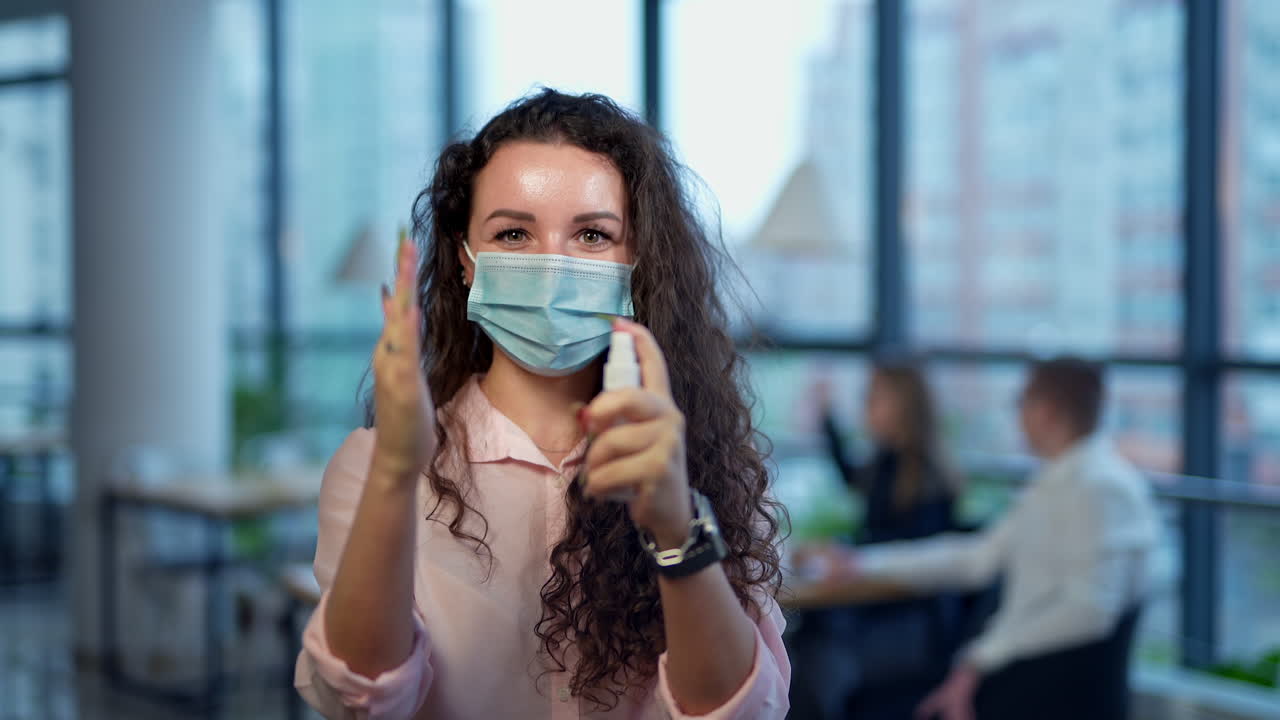 Woman Wearing Mask and Using Hand Sanitizer in Office