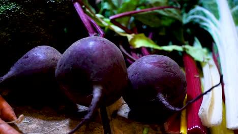 fresh vegetables, including purple beets, bok choi, and carrots, close up pan