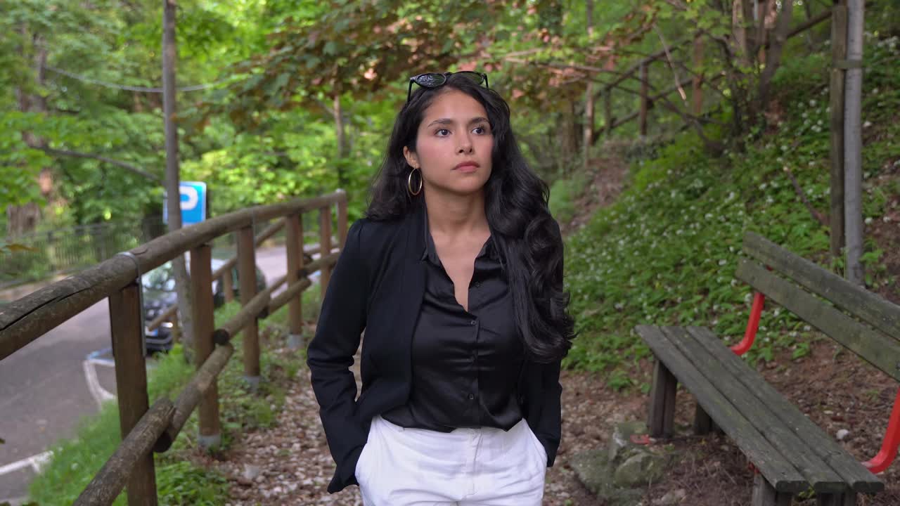 joven atractiva con ropa de clase sonríe mientras camina, vista delantera