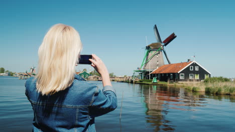 woman photographs dutch windmills