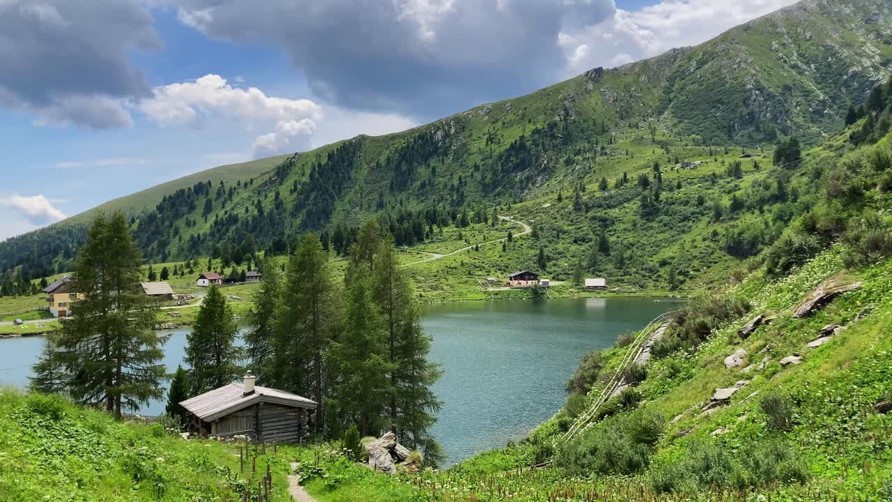 Un idilliaco lago cristallino e blu in una valle, circondato da un insediamento.