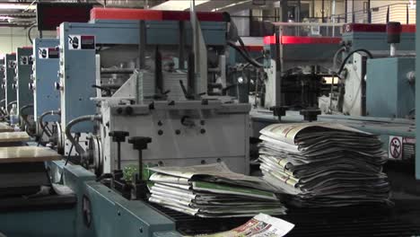 workers man the printing presses in a newspaper factory