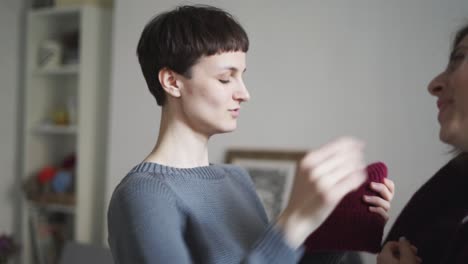 young woman fitting sisters hat in home. portrait of hipster girl fit wool hat